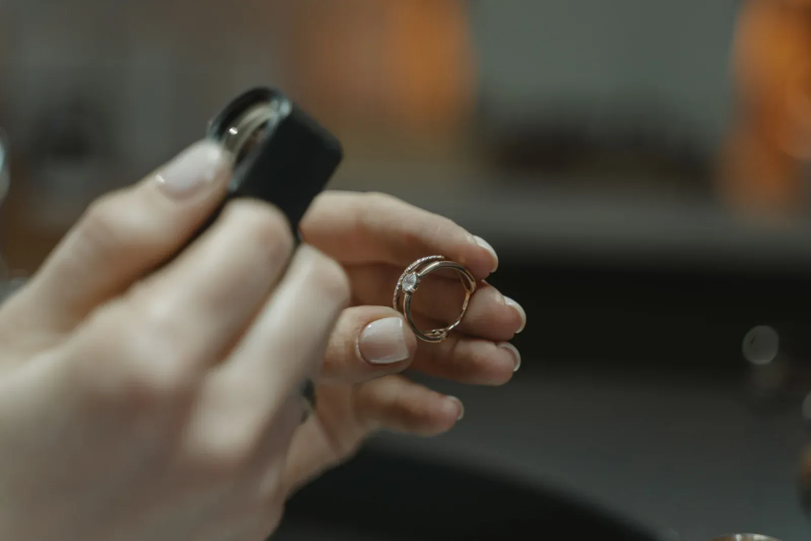 Hände prüfen einen Ring mit der Lupe