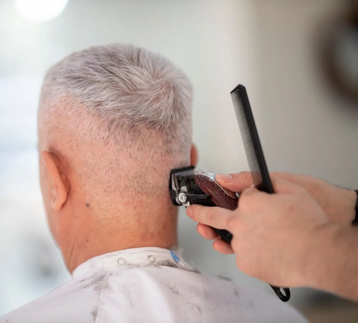 Kurzes graues Haar, der Nacken wird mit der Maschine ausgeputzt