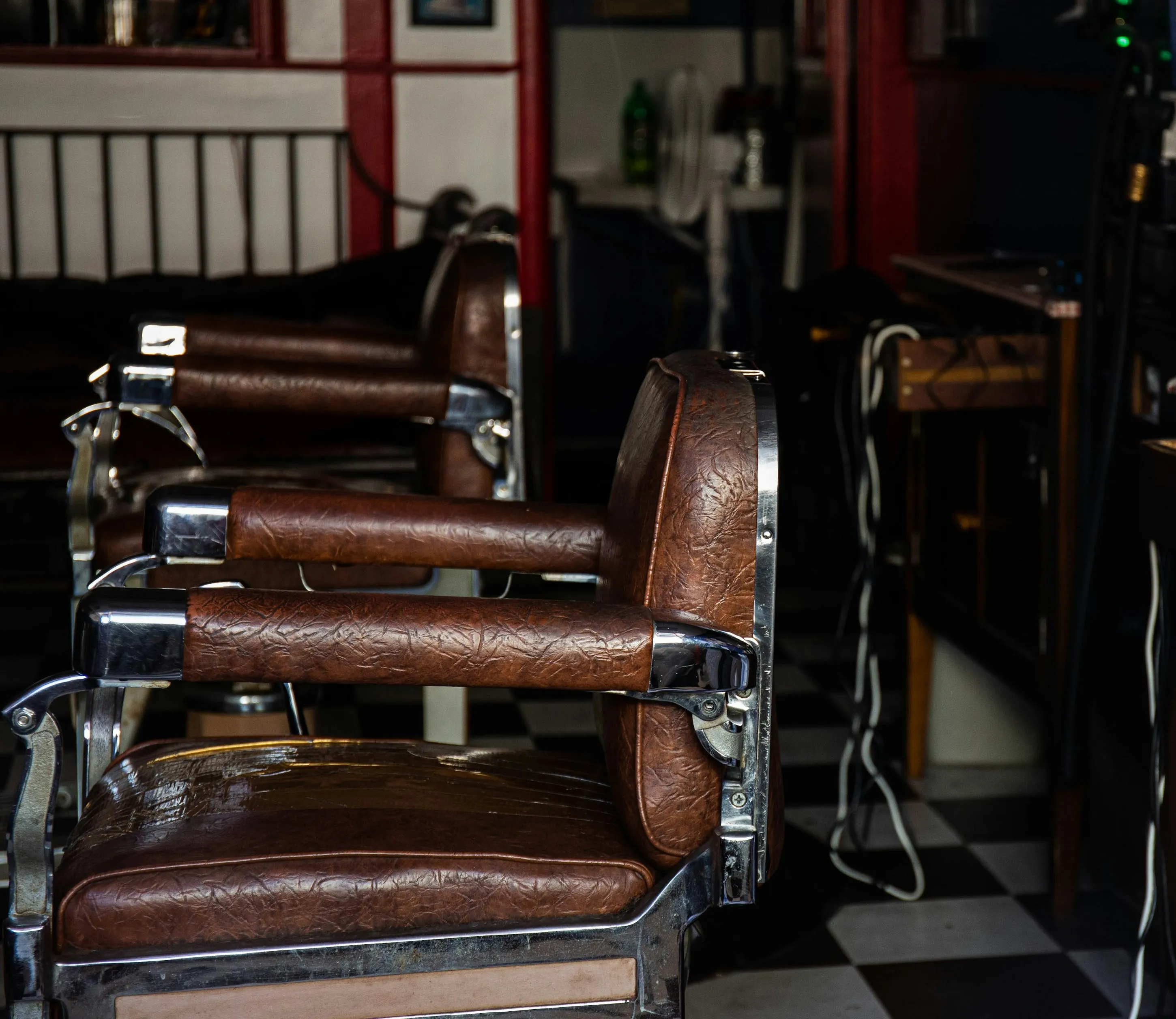 Leere Barbierstühle aus Leder in einem dunklen Salon