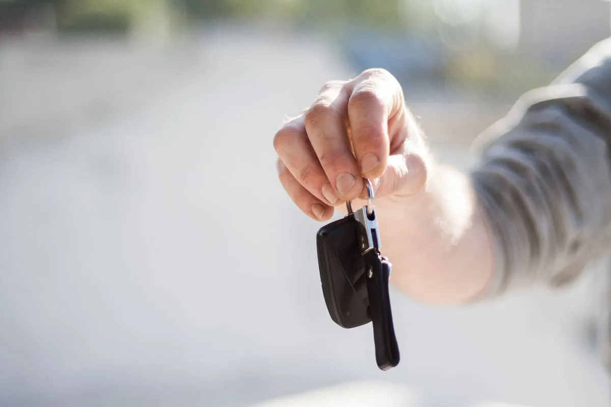 Eine Hand hält einen Autoschlüssel hin